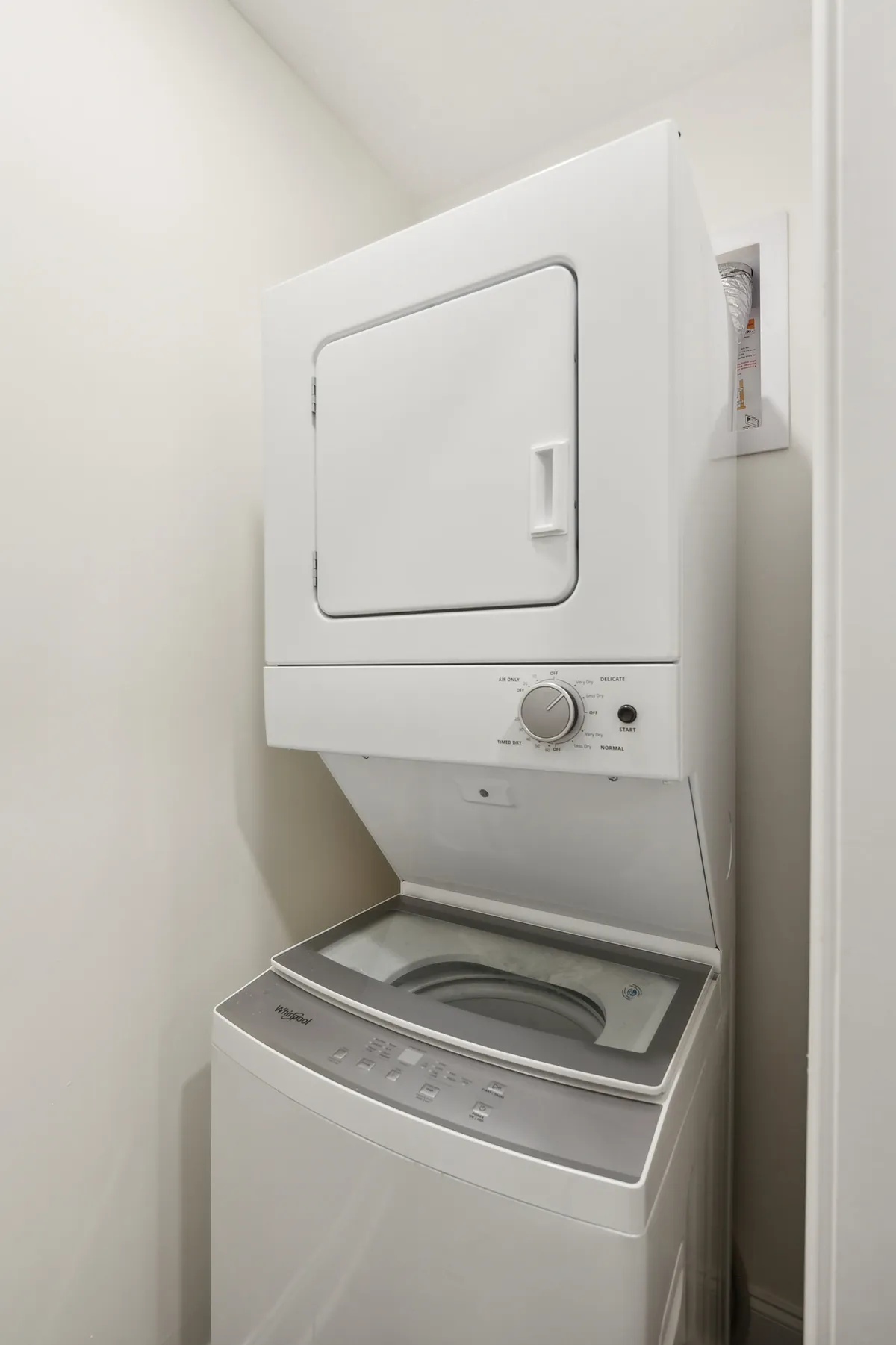 A practical laundry nook with a stacked washer and dryer, conveying convenience and efficiency for daily living. The clean, organized space underlines the home's turnkey appeal.
